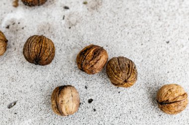 Açık gökyüzünün altında beyaz ve açık gri köpük bir blokta kahverengi kabuklu çiğ ceviz. Sonbahar mevsimi, birkaç meyve mahsulü.
