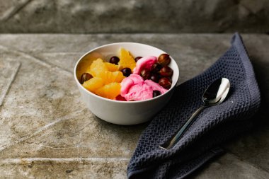 Yaz, meyve ve böğürtlenli taze tatlı. Portakal suyu ve bektaşi üzümlü bir kasede pembe dondurma..