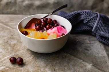 Yaz, meyve ve böğürtlenli taze tatlı. Portakal suyu ve bektaşi üzümlü bir kasede pembe dondurma..