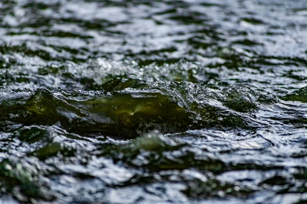 流动的淡水 带着飞沫旋转的电流 浅绿色的色调 在河里透明的液体 像小波浪的背景和质感 — 图库照片