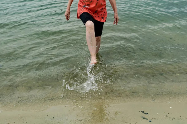 女人的脚赤脚在沙滩湿岸的水里 淡水海滩 走在河岸上 两条腿靠得很近 — 图库照片