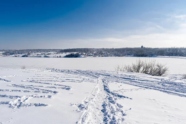 Spacious snow landscape. River and hills in Russia, white winter on the terrain, a lot of fluffy snow and ice under a beautiful blue sky. Rostov region, town of Shakhty, the river Grushevka