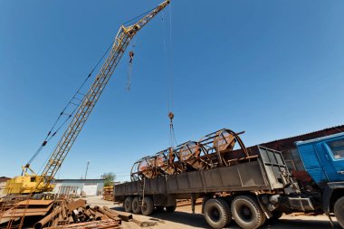 Yapıların büyük metal kamyona endüstriyel kaide üzerinde bir vinç ile yükleme