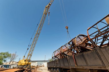 Yapıların büyük metal kamyona endüstriyel kaide üzerinde bir vinç ile yükleme