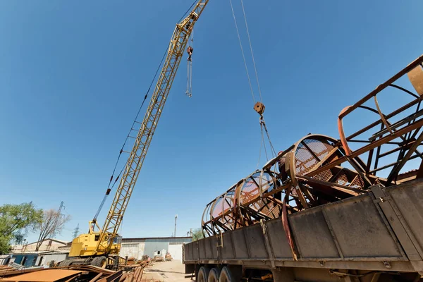 Yapıların büyük metal kamyona endüstriyel kaide üzerinde bir vinç ile yükleme