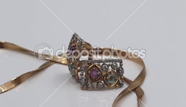 Küçük değerli taşlar yakın çekim ile Altın Küpe Altın bir zincir ile güzel bir örgü ile yalan