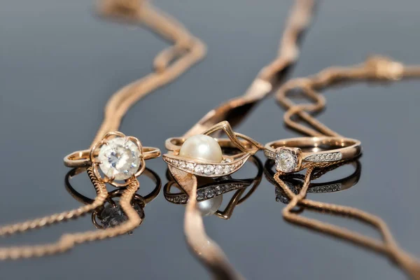 Gold Rings Diamonds Pearls Precious Stones Lie Reflective Surface Three — Stock Photo, Image