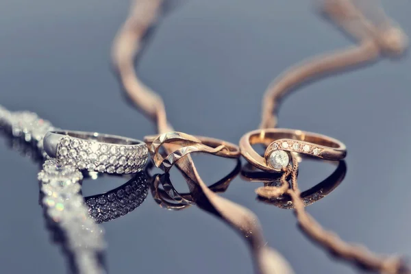 金戒指与钻石 珍珠和宝石位于反光表面与三不同的链 — 图库照片