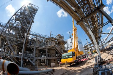 Bir büyük 100 tonluk bir kamyon vinç gelişeceğini bacakları ve genişletilmiş boom ile yeni Petrokimya Kompleksi dükkanı inşaatta standları
