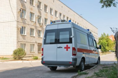 Yeni bir beyaz ambulans van karmaşık hastane yanında duruyor