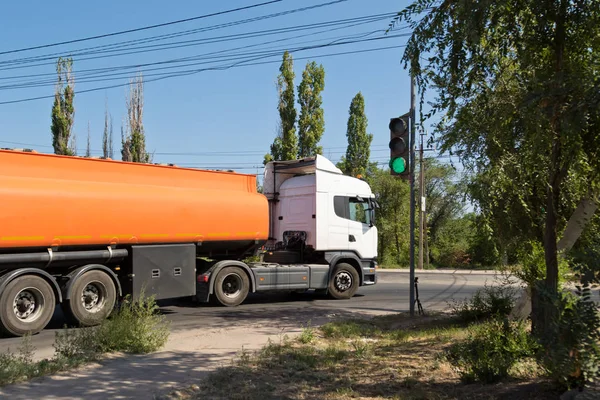 一辆卡车与一辆坦克运输石油产品在工业地区在尘土飞扬的道路上行驶 — 图库照片