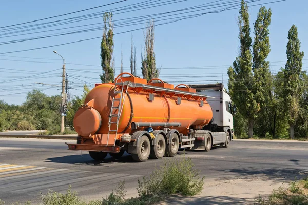 一辆卡车与一辆坦克运输石油产品在工业地区在尘土飞扬的道路上行驶 — 图库照片