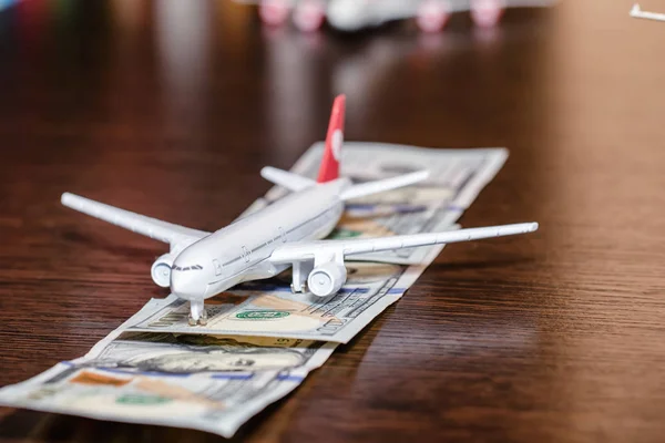 Toy airplane on the runway of hundred dollar bills