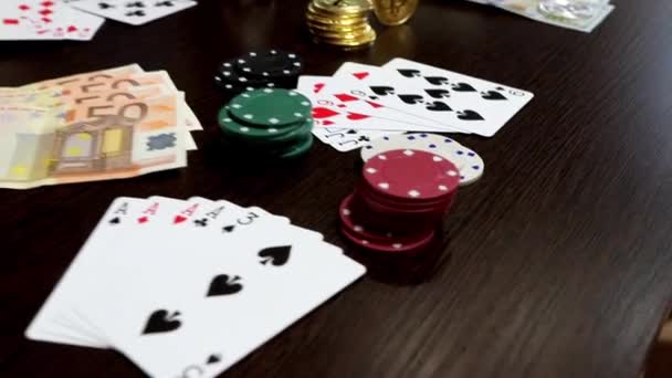 Atributos do jogo em uma mesa de madeira - dinheiro, cartas, fichas de jogo e bitcoins — Vídeo de Stock