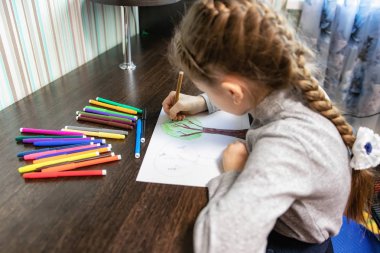 Junior Sınıf evde ödev çizimindeki masada oturan bir öğrenci