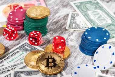 Renkli casino fişi, dolar, bitcoins ve kırmızı zar üzerinde ahşap masa lambası yalan