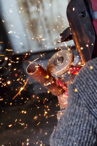 用切割机加工根焊缝 火花飞向不同的方向 焊工佩戴安全带系绳 观察安全 — 图库照片