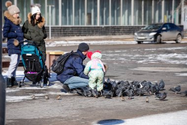 İnsanlar meydanda yürümeye beslemek güvercinler ve tohum ile serçe