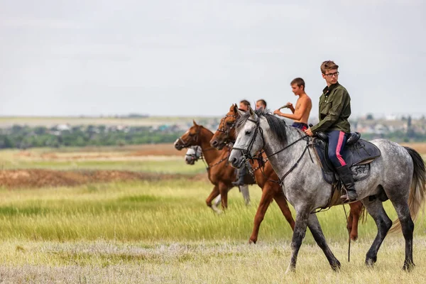 Молодые парни и девушки ездят в поле на своих лошадях — стоковое фото