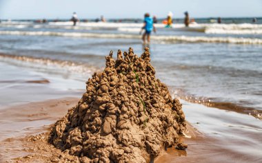 Tatil plajı Hazar kıyısında çocuklar tarafından inşa edilmiş kum dansı 