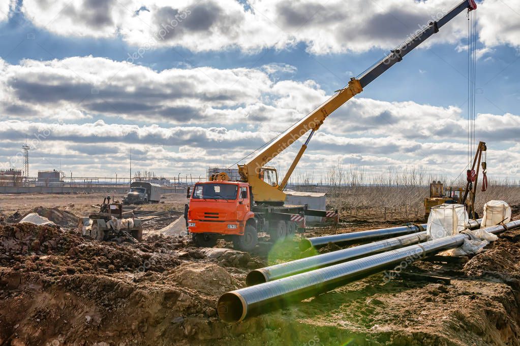 Construction work on pipe laying of pipeline into the trench usi