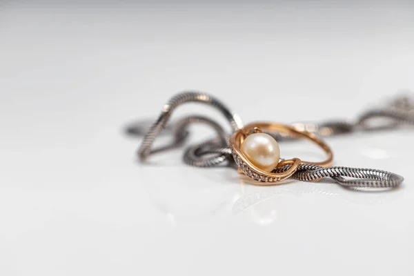 Stříbrný řetízek a zlatý perlový prsten — Stock fotografie