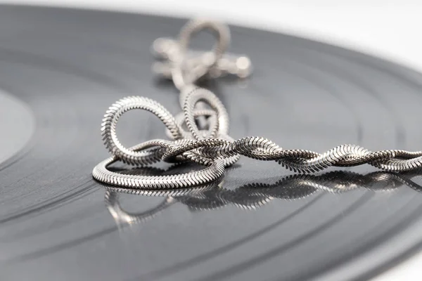 Een zilveren ketting met een elegant design is verdraaid in ringen en — Stockfoto