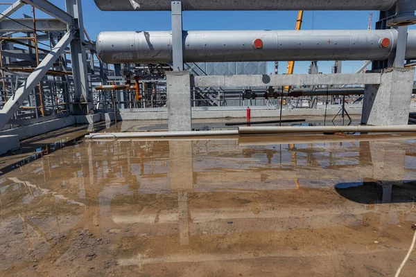 建設中の石油精製複合施設のオープンエリアに大雨の後の大きな水たまり — ストック写真