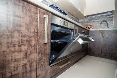 Modern mutfak iç mimarisi koyu renkli ve dahili cihazlı.