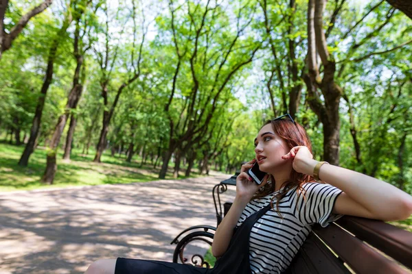 Encantadora Menina Ruiva Sentada Banco Parque Falando Telefone Celular — Fotografia de Stock
