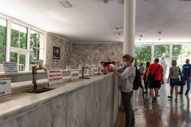 ESSENTUKI 19 AĞUSTOS: Spa kasabasının turistleri koruyucu maskelerle maden suyu içme galerisini ziyaret ediyorlar. 19 Ağustos 2020 Essentuki, Rusya.