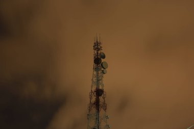 Telekomünikasyon kule anten ve uydu çanağı günbatımı gökyüzü arka plan.