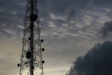 Telekomünikasyon kule anten ve uydu çanağı günbatımı gökyüzü arka plan.