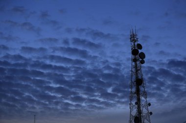 Telekomünikasyon kule anten ve uydu çanağı günbatımı gökyüzü arka plan.