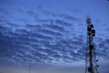 Telekomünikasyon kule anten ve uydu çanağı günbatımı gökyüzü arka plan.