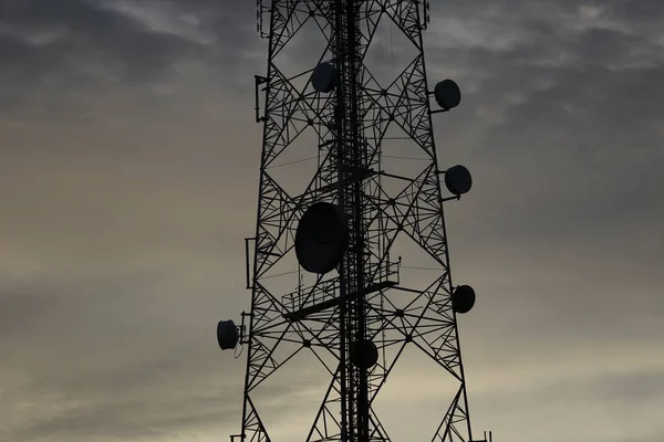 Telekomünikasyon kule anten ve uydu çanağı günbatımı gökyüzü arka plan.