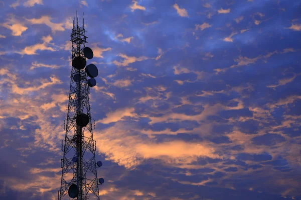 Telekomünikasyon kule anten ve uydu çanağı günbatımı gökyüzü arka plan.