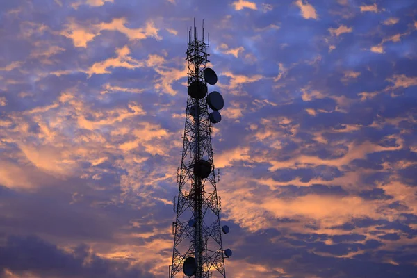 Telekomünikasyon kule anten ve uydu çanağı günbatımı gökyüzü arka plan.