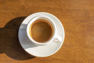 Espresso kahve sıcak altın sabah güneşi ile ahşap arka plan.