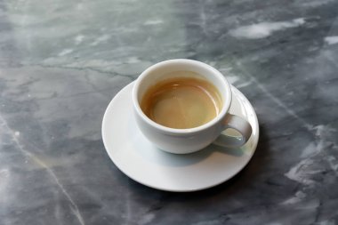 Taş masada sıcak siyah kahve.