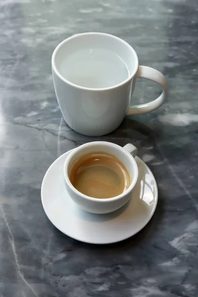 Café expresso com água morna em vidro branco . — Fotografia de Stock