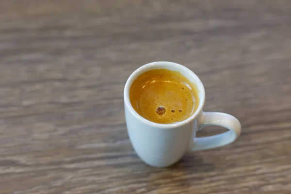 Café expreso oro caliente en fondo de madera . — Foto de Stock