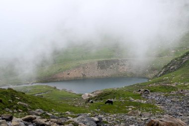 Dağ yansıma mavi gökyüzü göl içinde ışıklı doruklarına taş olan yüksek kayalar ile muhteşem manzara.