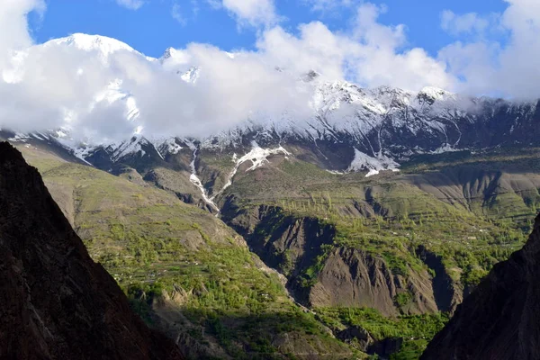 View over the hill with mountain trail and snowy mountains on the background. Beautiful mountain trail landscape.