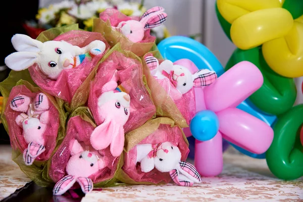 Bouquet of toys.Bouquet of cute stuffed rabbits on a background of balloons and flowers.