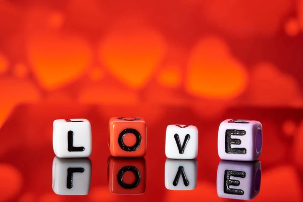 Word love  from cubes with reflection on bright blurred background.