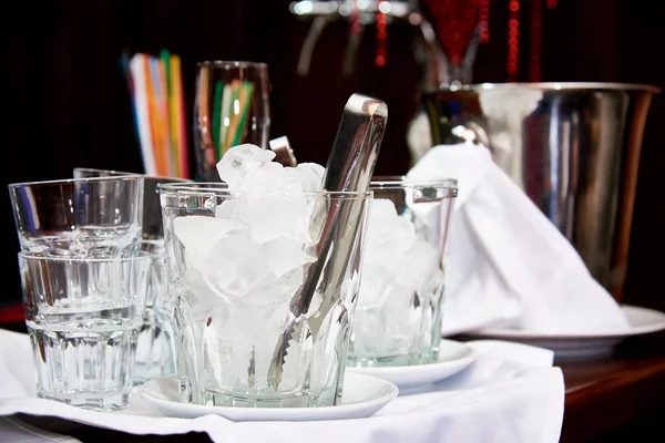 Glass bucket with ice cubes on the bar.