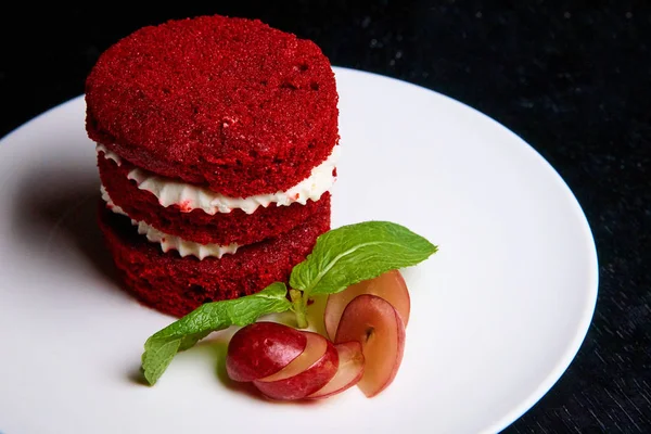 Red velvet cake and fresh apple on a white plate.