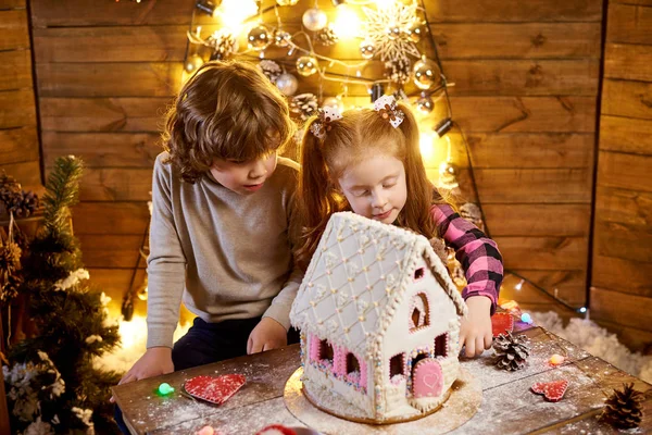 Happy children with christmas gingerbread in a decorated room to the holiday.
