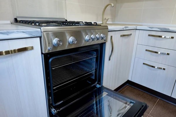 Open oven in an empty kitchen in an apartment.